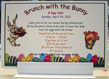 Table-top sign for a hotel Easter brunch, set in Comic Sans with clip-art bunnies and eggs: "Brunch with the Bunny & Egg Hunt"
